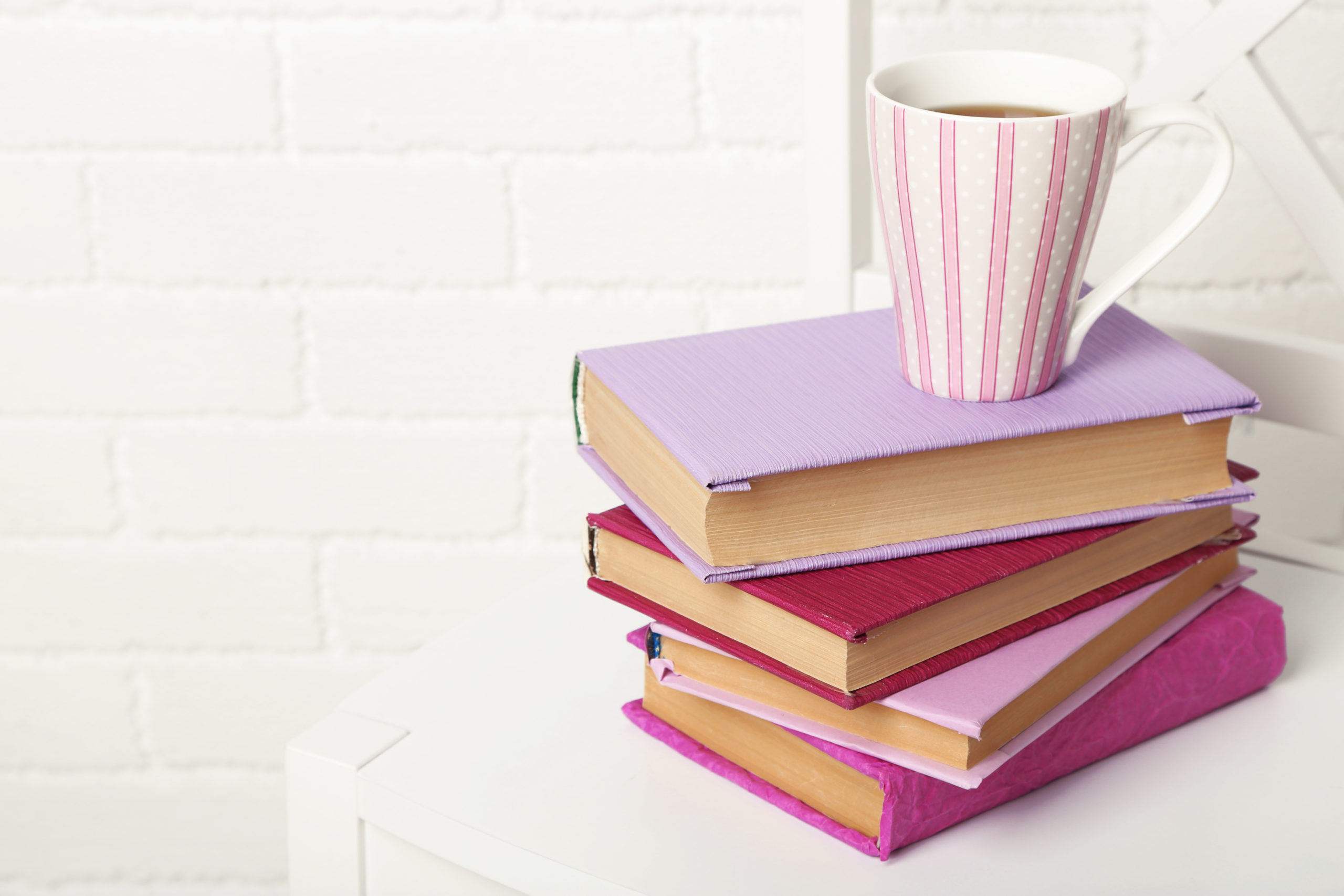 Pink striped cup on top of books